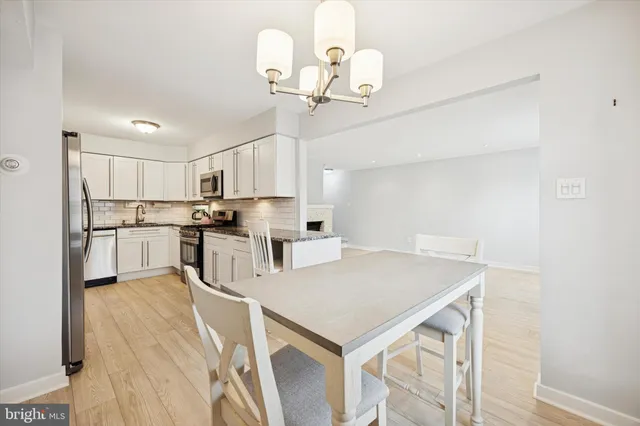 a kitchen with kitchen island a table chairs refrigerator and cabinets