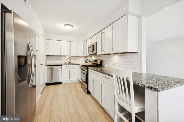 a kitchen with stainless steel appliances granite countertop a refrigerator sink and cabinets