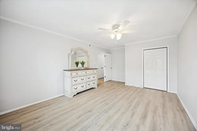 a view of a bedroom with wooden floor and ceiling fan