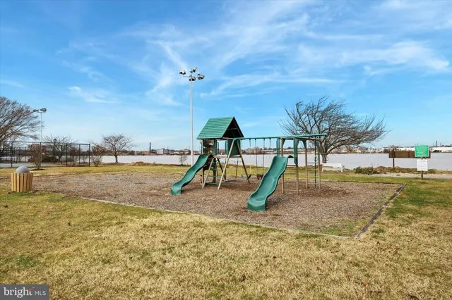 a view of a swimming pool with a yard and palm trees