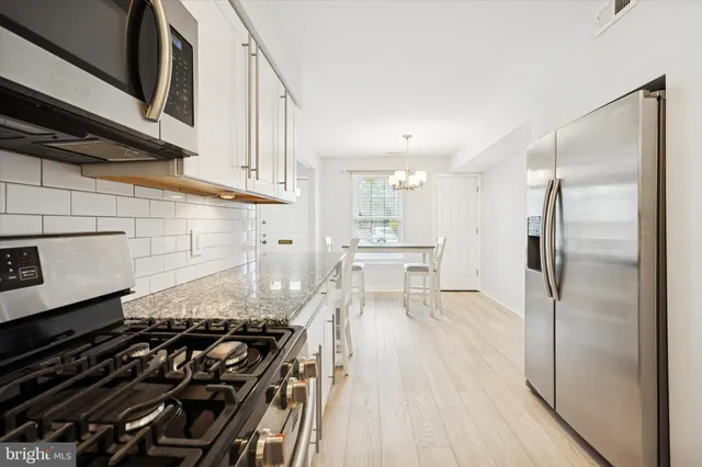 a kitchen with granite countertop a stove and a refrigerator