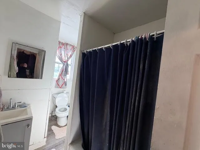 a bathroom with a toilet and a shower curtain