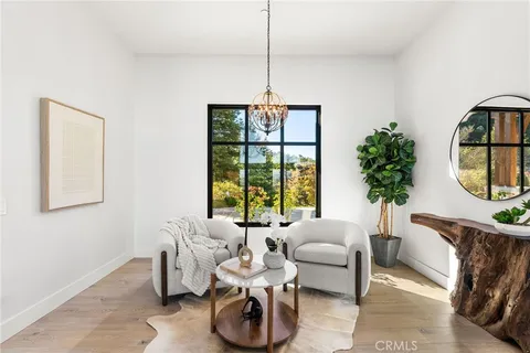 a living room with furniture kitchen view and a large window