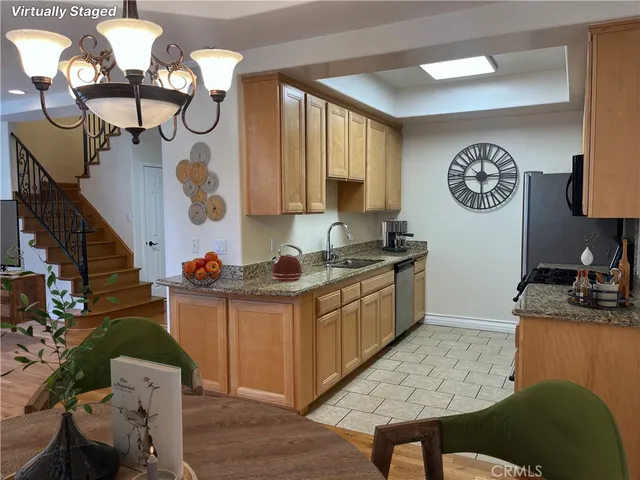 a kitchen with stainless steel appliances granite countertop a sink a stove and a wooden floors