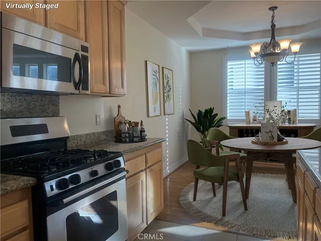 a kitchen with stainless steel appliances a stove a sink cabinets and a dining table