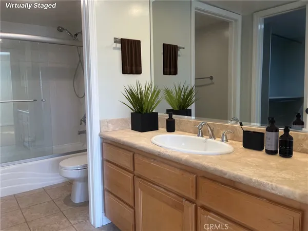 a bathroom with a granite countertop sink a toilet and shower
