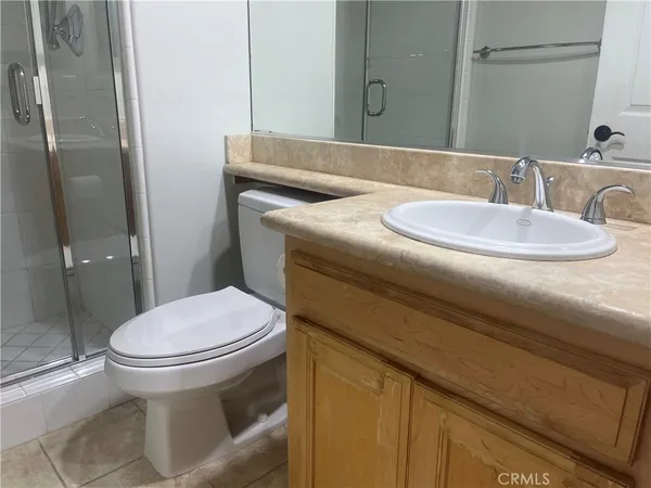 a bathroom with a granite countertop toilet sink and mirror