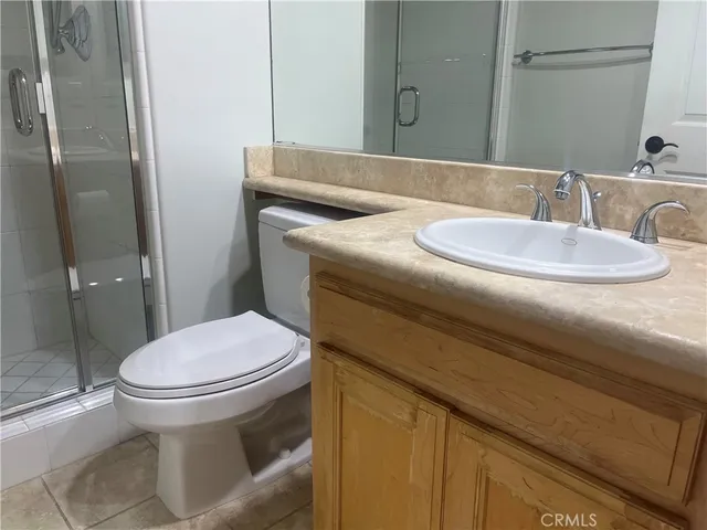 a bathroom with a granite countertop toilet sink and mirror