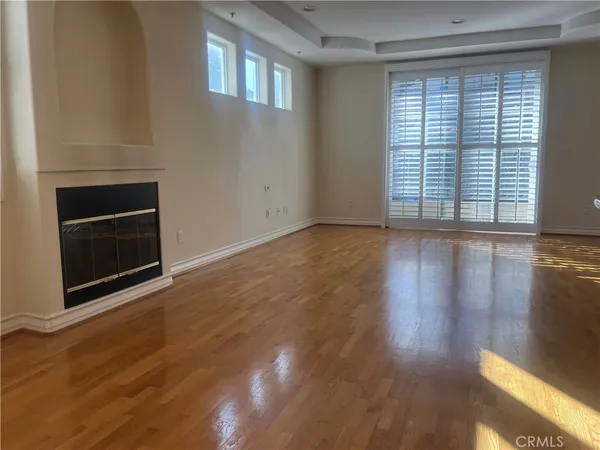 an empty room with wooden floor and fireplace