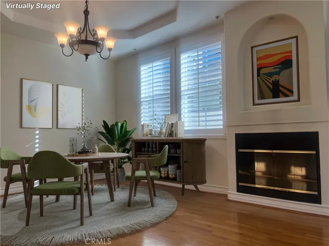 a dining room with furniture a fireplace and wooden floor