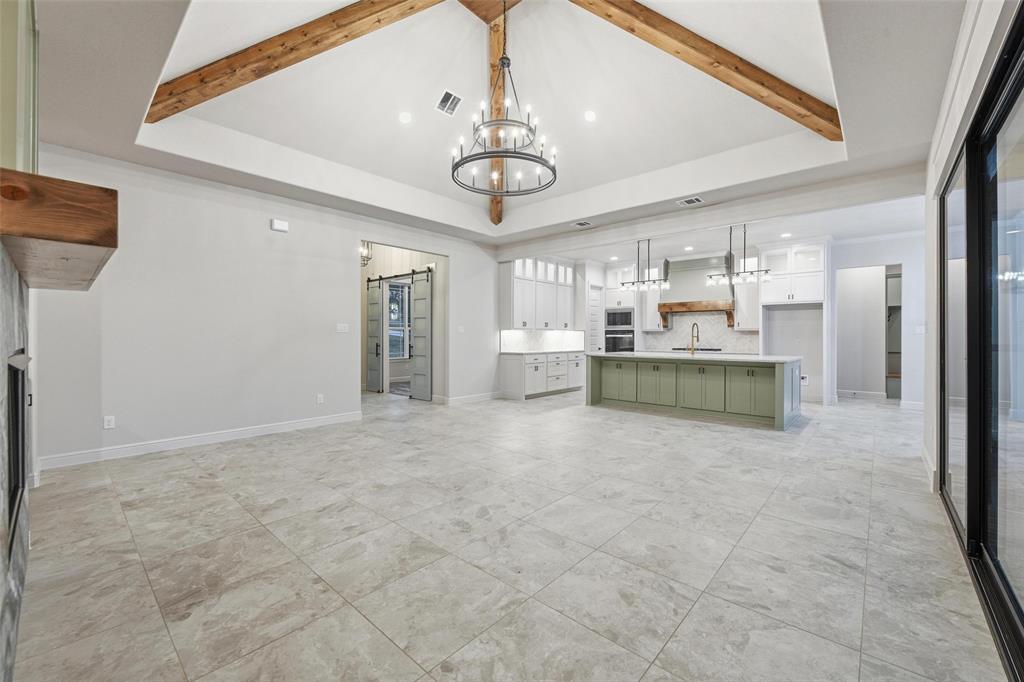 189 Rio Rancho Drive Decatur, TX 76234 - Photo 11 of 36 Unfurnished living room featuring a barn door, a chandelier, beamed ceiling, and recessed lighting