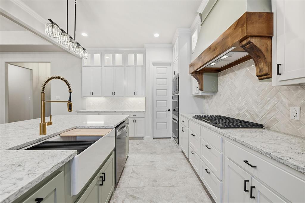 189 Rio Rancho Drive Decatur, TX 76234 - Photo 11 of 34 Kitchen with white cabinetry, pendant lighting, light stone counters, backsplash, and glass insert cabinets