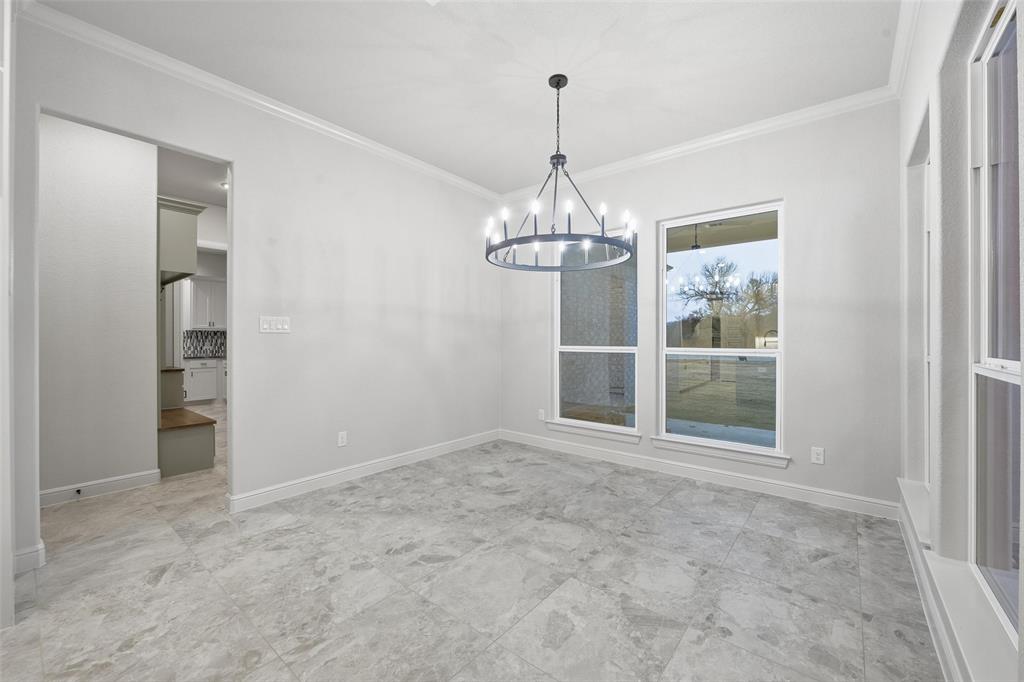 189 Rio Rancho Drive Decatur, TX 76234 - Photo 15 of 36 Unfurnished dining area with ornamental molding and a chandelier