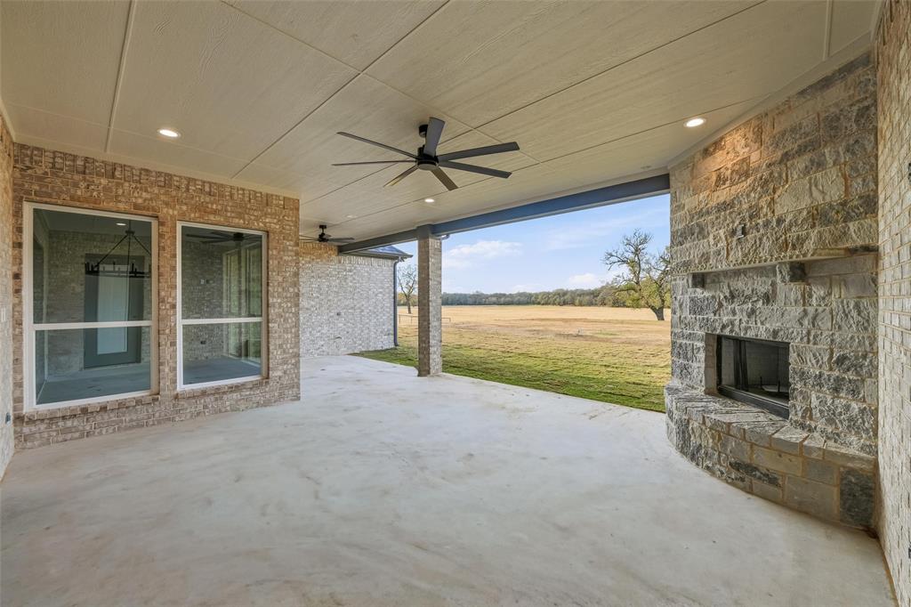 189 Rio Rancho Drive Decatur, TX 76234 - Photo 33 of 34 View of patio / terrace with a ceiling fan and an outdoor stone fireplace