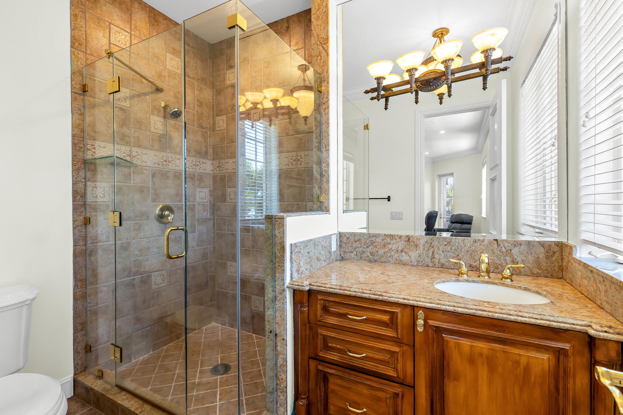 3700 Northeast 28th Avenue Lighthouse Point, FL 33064 - Photo 50 of 77 a bathroom with a granite countertop sink a mirror a glass door a shower and vanity