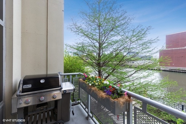 700 North Larrabee Street, Unit 115 Chicago, IL 60654 - Photo 16 of 20 a balcony with wooden floor and trees in the back