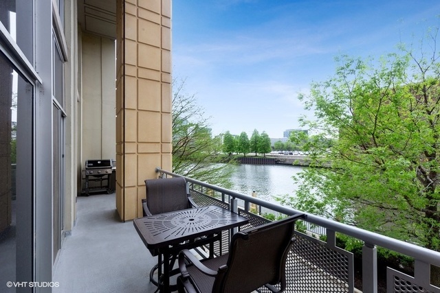 700 North Larrabee Street, Unit 115 Chicago, IL 60654 - Photo 18 of 20 a balcony with wooden floor table and chairs