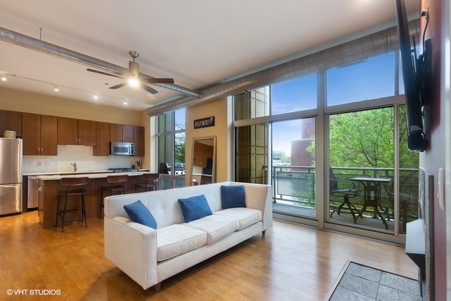700 North Larrabee Street, Unit 115 Chicago, IL 60654 - Photo 4 of 20 a living room with furniture a large window and wooden floor