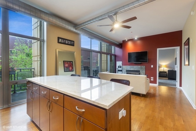700 North Larrabee Street, Unit 115 Chicago, IL 60654 - Photo 5 of 20 a view of kitchen island a sink and a fireplace