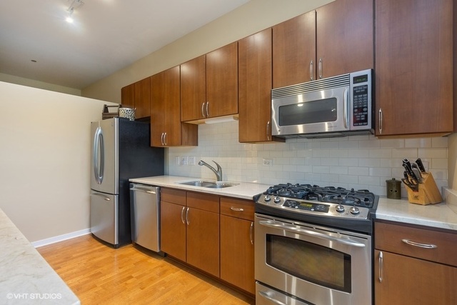 700 North Larrabee Street, Unit 115 Chicago, IL 60654 - Photo 7 of 20 a kitchen with a stove a microwave and refrigerator