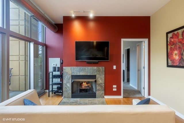 700 North Larrabee Street, Unit 115 Chicago, IL 60654 - Photo 8 of 20 a living room with fireplace furniture and a flat screen tv