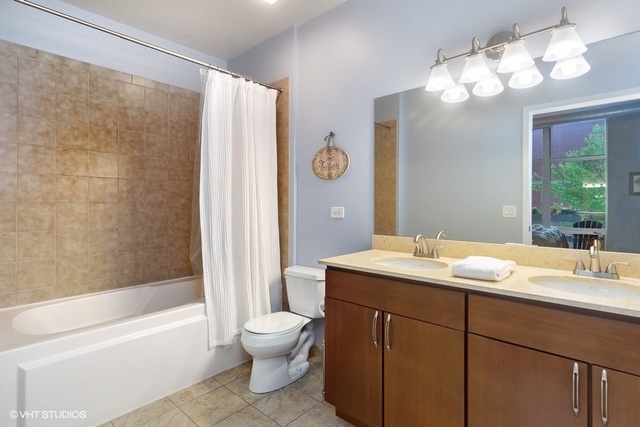 700 North Larrabee Street, Unit 115 Chicago, IL 60654 - Photo 10 of 20 a bathroom with a sink a toilet and a large mirror