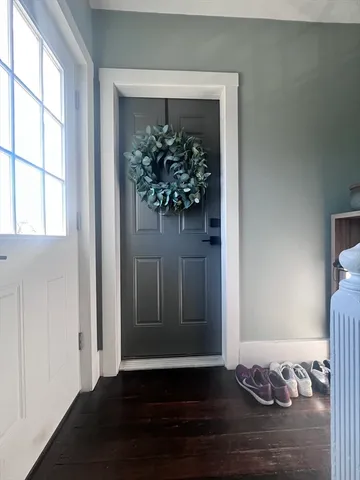 a view of a hallway with wooden floor and a window