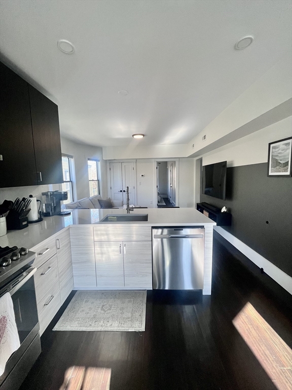 27 Armandine Street, Unit 3 Boston, MA 02124 - Photo 4 of 17 a kitchen with stainless steel appliances kitchen island granite countertop a stove top oven a sink a counter space and cabinets