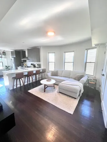 a living room with lots of furniture and a wooden floor