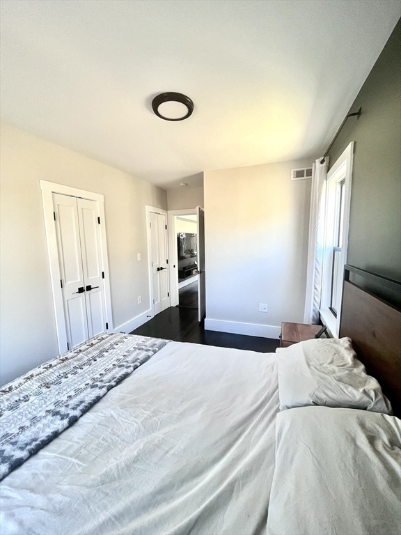 27 Armandine Street, Unit 3 Boston, MA 02124 - Photo 9 of 17 a large bedroom with a bed and a large mirror