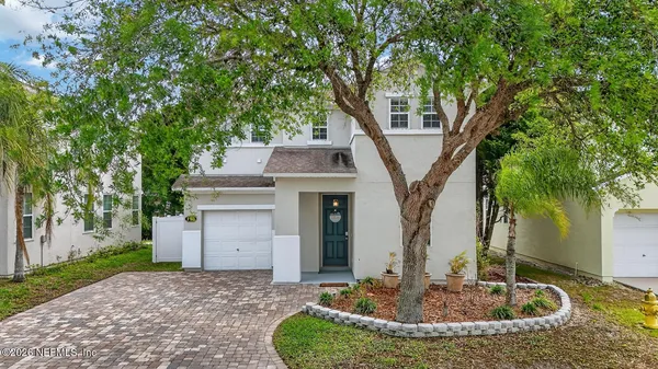 a front view of a house with a tree