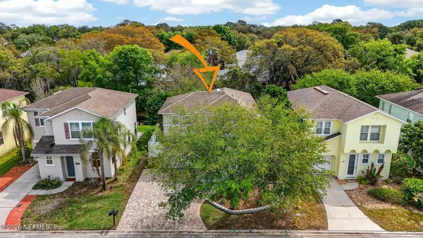 an aerial view of residential houses with outdoor space and trees