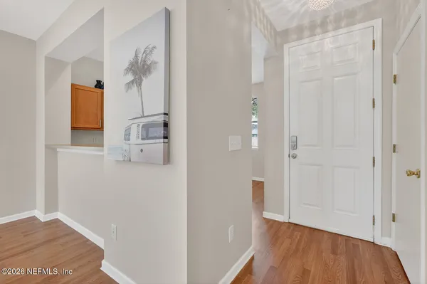 a view of empty room with wooden floor and chandelier