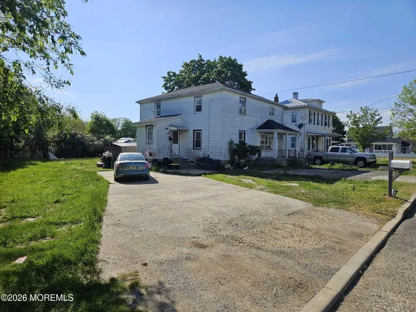a front view of a house with a yard and trees