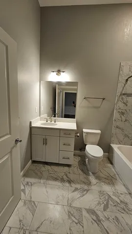 a bathroom with a sink toilet a mirror and bathtub