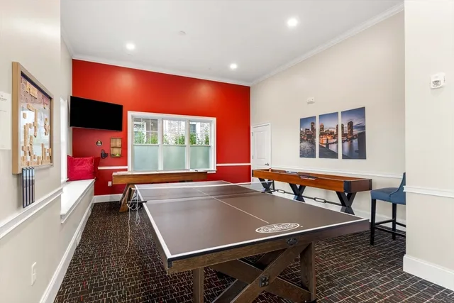 a room with wooden floor table tennis pool table and windows