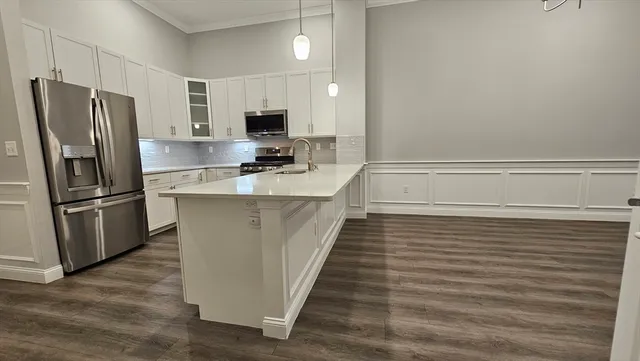 a kitchen with stainless steel appliances a refrigerator and a stove top oven