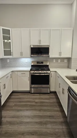 a kitchen with cabinets appliances and a sink