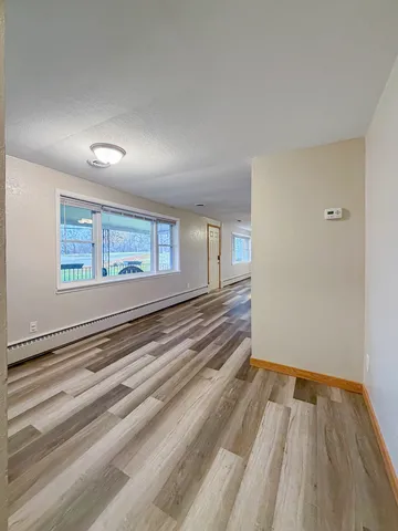a view of a room with wooden floor and windows
