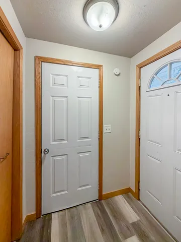 an empty room with wooden floor and closet area