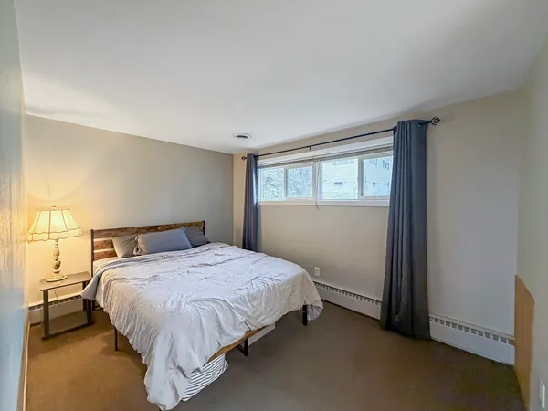 a bed sitting in a bedroom next to a window