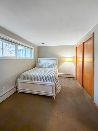 a spacious bedroom with a bed and a window