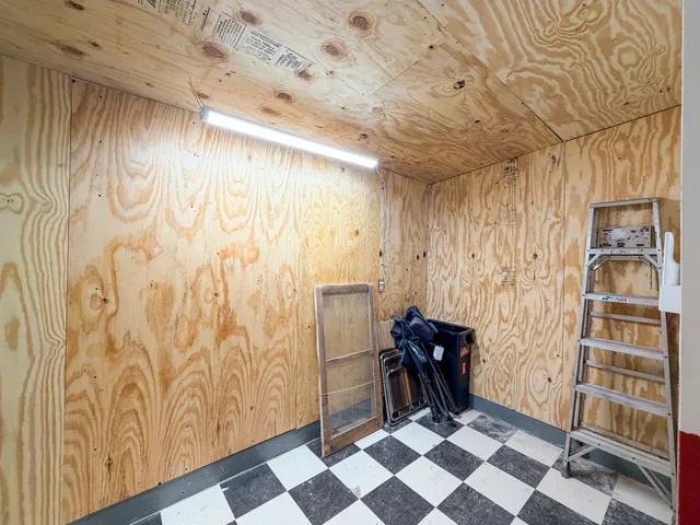 a room with a black white checkered floor with a mirror and a shower curtain