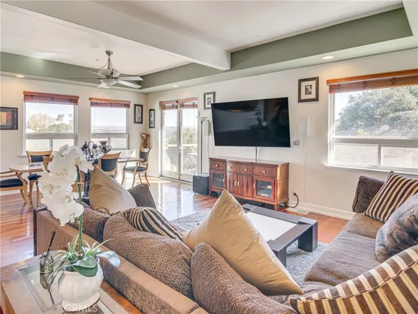 a living room with furniture a flat screen tv and a large window