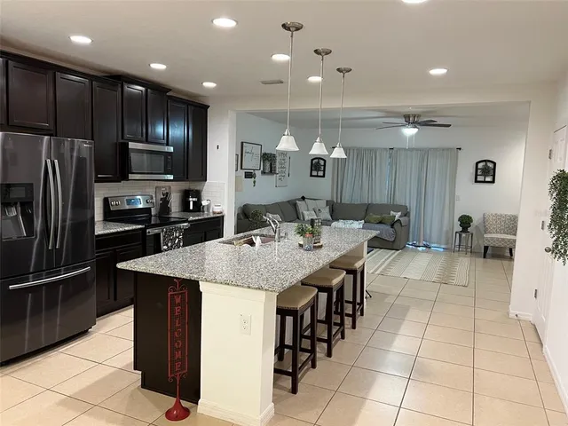 a large kitchen with kitchen island a sink stainless steel appliances and cabinets