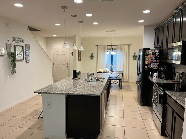 a kitchen with stainless steel appliances granite countertop a sink a stove and a refrigerator