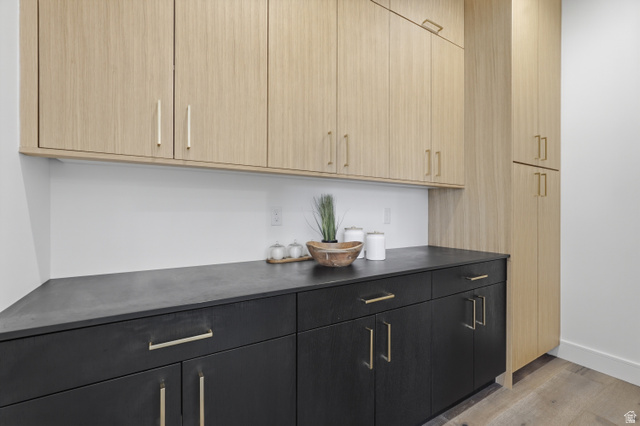 653 East Vandalay Lane Draper, UT 84020 - Photo 21 of 61 Cabinetry featuring light wood-finish upper units and full-height pantry, contrasted with dark wood-finish lower cabinets