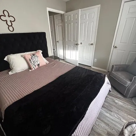 a bedroom with a bed and wooden floor