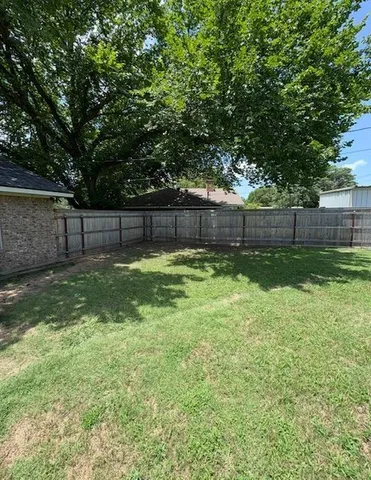 a view of a yard with a large tree and a swing