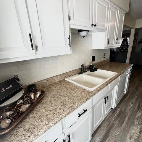 a kitchen with sink stove and cabinets